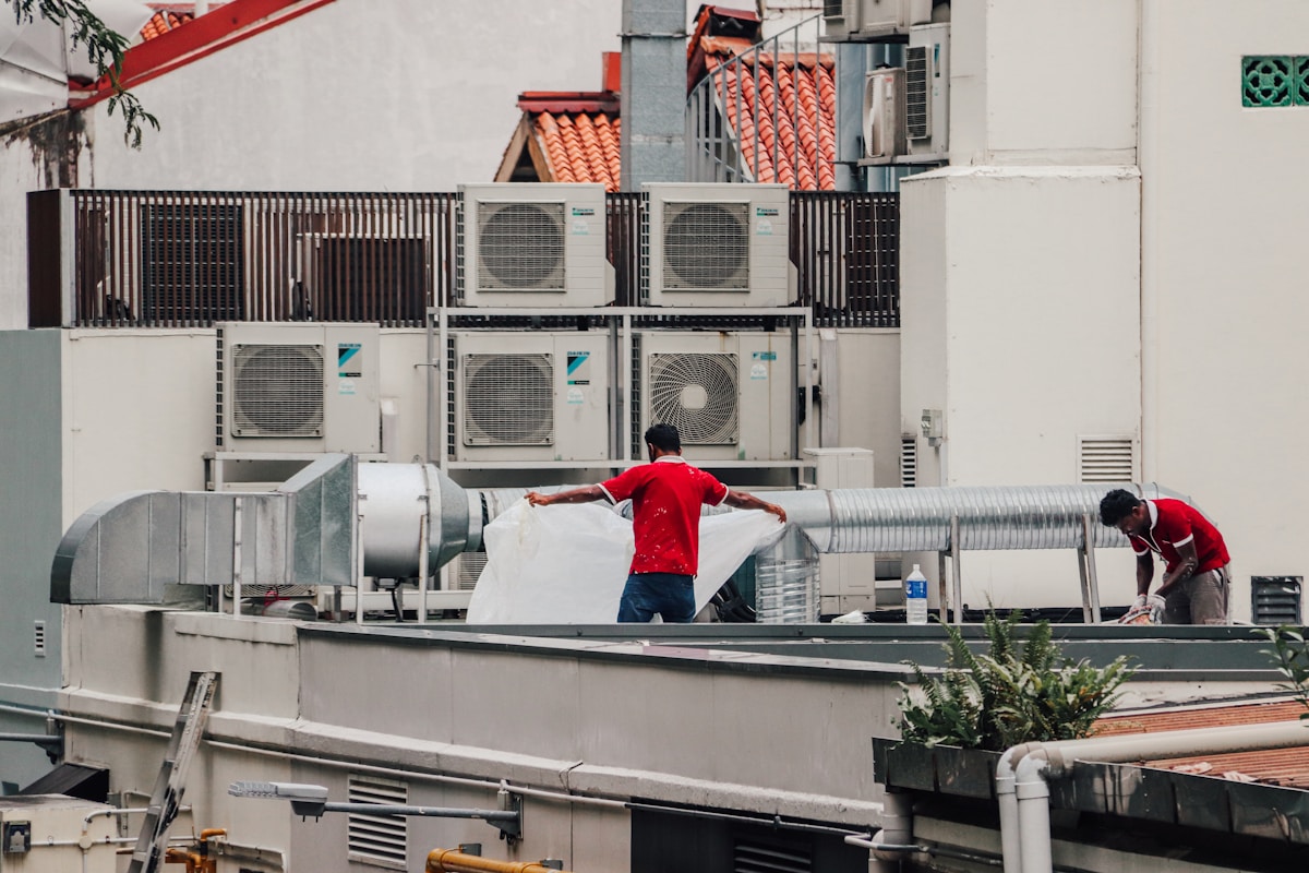 HVAC technicians installing air conditioning units on a rooftop