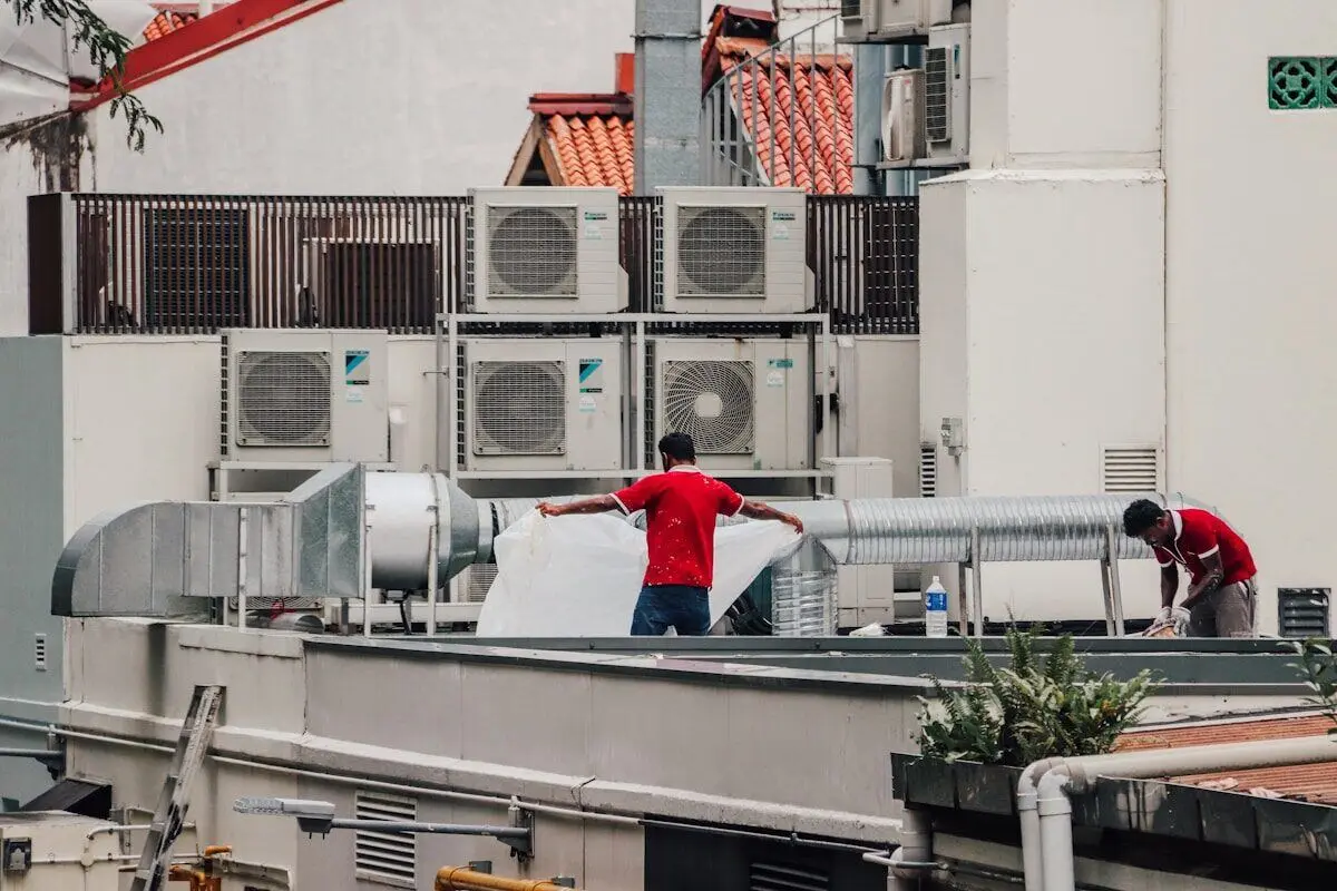 HVAC technicians installing air conditioning units on a rooftop