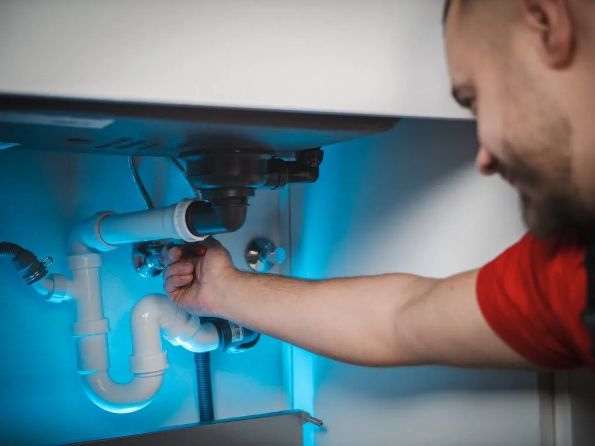 Plumber working under a kitchen sink